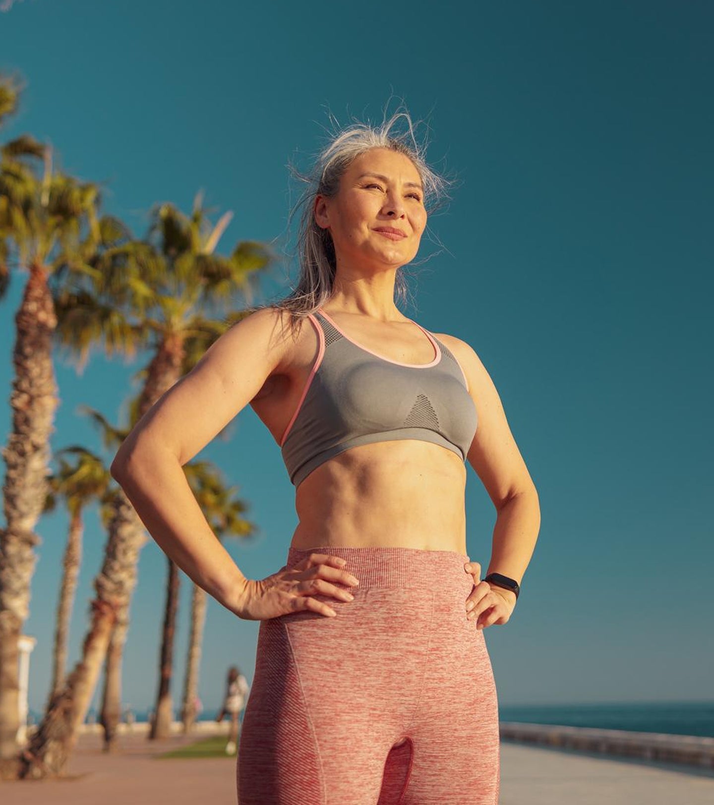 An active woman standing confidently on a beach